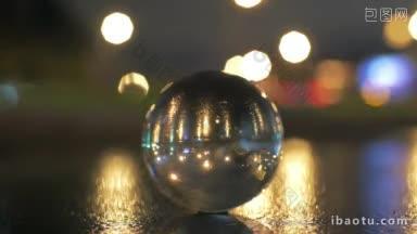 夜晚模糊的散景背景下，玻璃球成像倒立的城市景观
